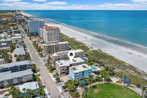 A coastal hotel with multiple buildings, a beach, and a pier. - Sunrise Beachside Oasis & Pool (Jacksonville Beach)