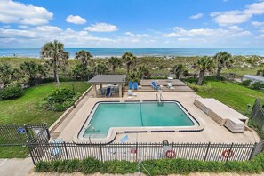 Ein Pool mit Blick auf Strand und Meer.