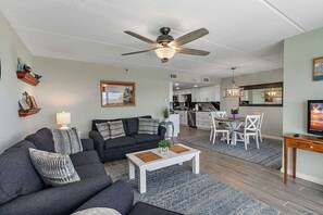 Ein Wohnzimmer mit einer Couch, einem Couchtisch und einem Deckenventilator.