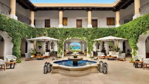 A courtyard with a fountain, outdoor seating, and a view of the sea. - Presidential 2-bedroom suite in enchanting San José del Cabo (San José del Cabo)