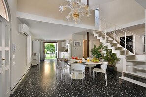 Eine moderne Küche mit Essbereich, einer Treppe und Blick ins Freie.