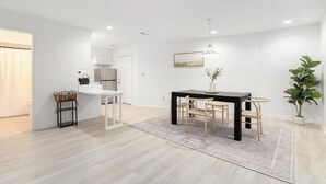A modern kitchen with white cabinets, a black dining table, and a grey rug. - Lake-View Hideaway | Beaches | Wineries (Sawyer)