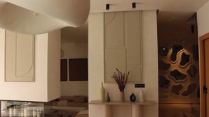 Een modern interieur met een open haard, een consoleschrank met decoratieve objecten en een uniek wandontwerp.