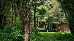 A forested area with a swing set and a stone wall. - Casa del Pisonay (family-friendly—up to 14 people, your nature retreat, Arin) (Calca)