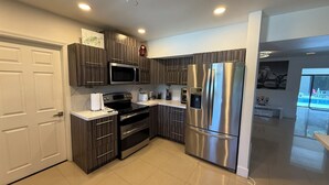 Una cocina moderna con un refrigerador de acero inoxidable, un microondas y una estufa.