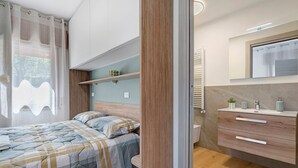 Ein modernes Schlafzimmer mit Bett, Nachttisch und integriertem Kleiderschrank.