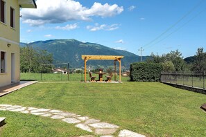 A grassy yard with a wooden pergola and a stone pathway. - Room 'Monte Grappa View' with Mountain View, Wi-Fi and Air Conditioning (Alano di Piave)
