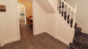 Ein Flur mit einer Treppe, die zu einem Essbereich führt.