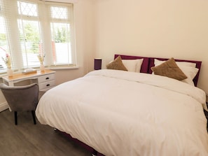 A bedroom with a bed, a desk, and a chair. - William's Place (Barry)