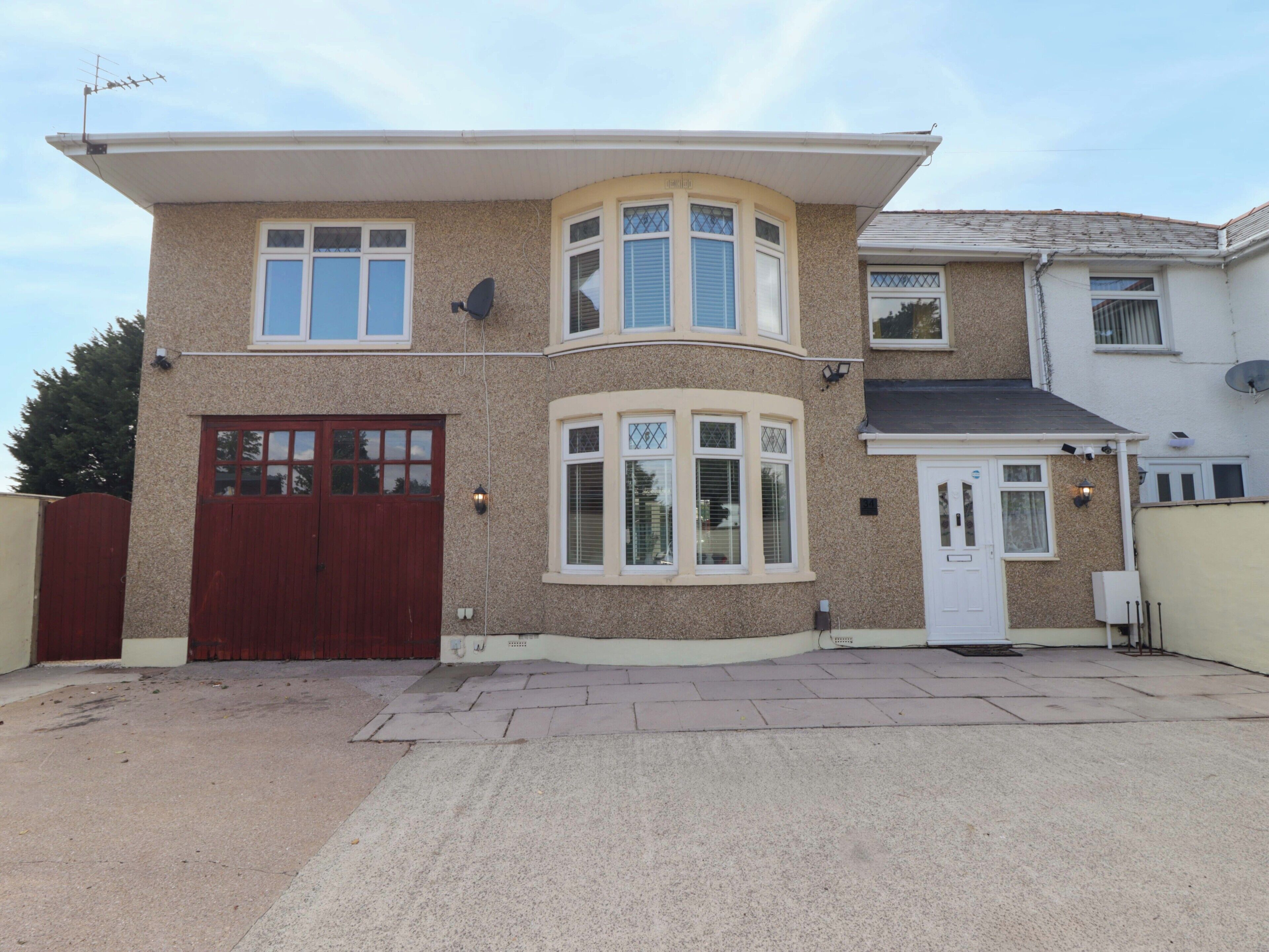 A two-story house with a garage, a bay window, and a satellite dish.