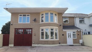 Ein zweigeschossiges Haus mit Garage, Erkerfenster und Satellitenschüssel.