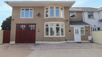 A two-story house with a garage, a bay window, and a satellite dish.
