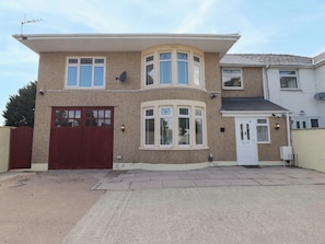 A two-story house with a garage, a bay window, and a satellite dish. - William's Place (Barry)
