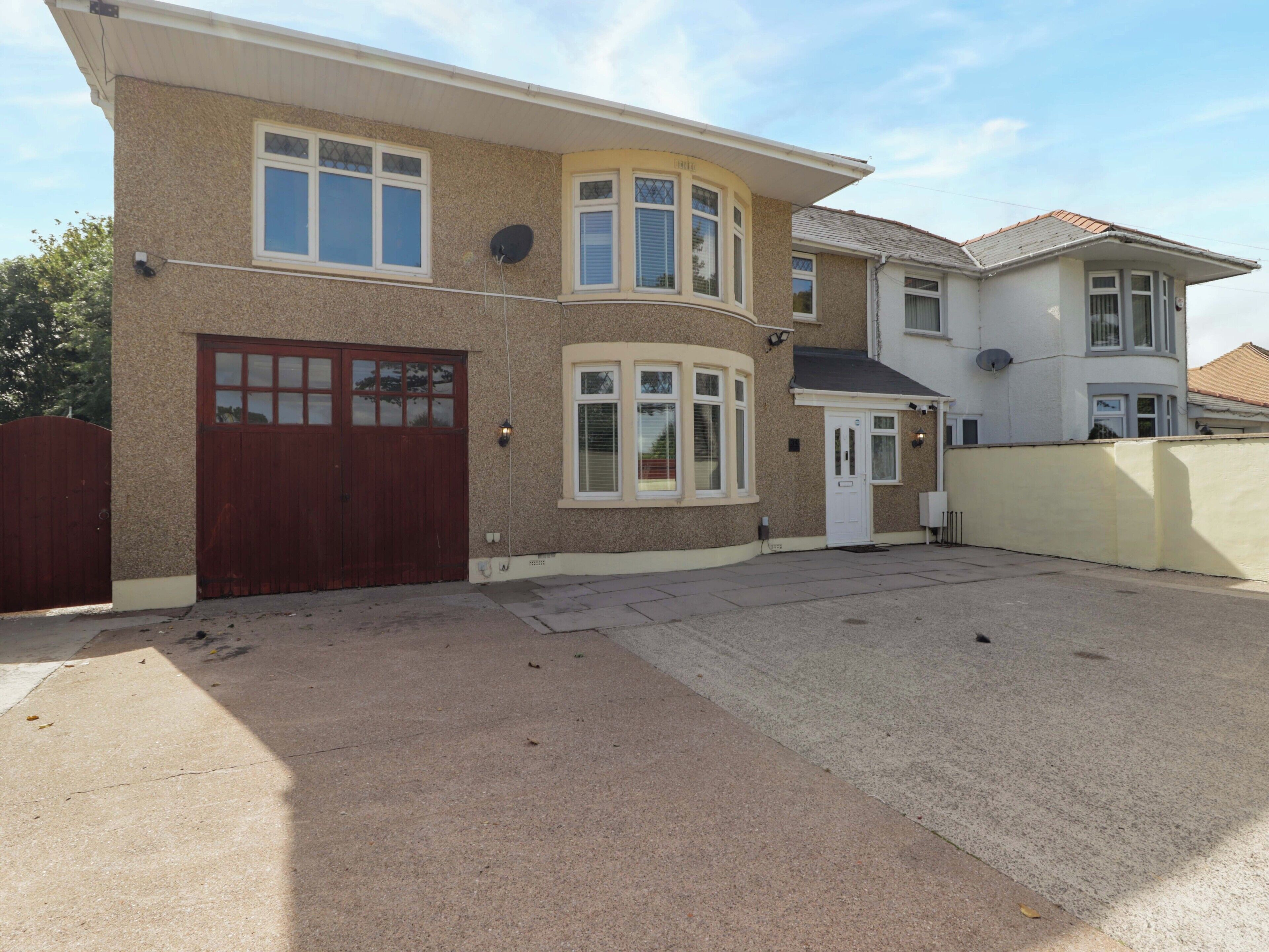 A two-story house with a garage, a front door, and a driveway.