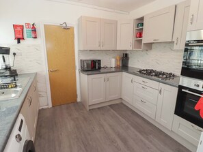 A kitchen with a microwave, stove, and cabinets. - William's Place (Barry)