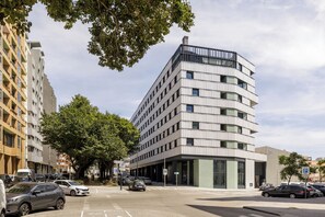 A multi-story building with a modern design, featuring a mix of balconies and large windows. - Moov Hotel Matosinhos Sul (Matosinhos)