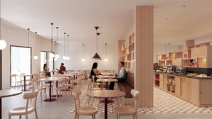 A modern dining area with multiple tables and chairs, pendant lighting, and a kitchen area with wooden cabinets and a display counter. - Moov Hotel Matosinhos Sul (Matosinhos)