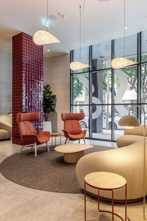 A modern lobby with seating areas, a large window with a view of the outdoors, and a unique ceiling design. - Moov Hotel Matosinhos Sul (Matosinhos)