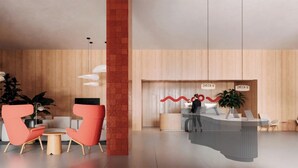 A modern reception area with a check-in desk, seating area with chairs, and a large plant. - Moov Hotel Matosinhos Sul (Matosinhos)