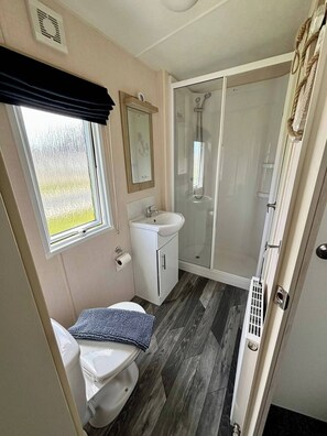 Ein Badezimmer mit Toilette, Waschbecken und Dusche.
