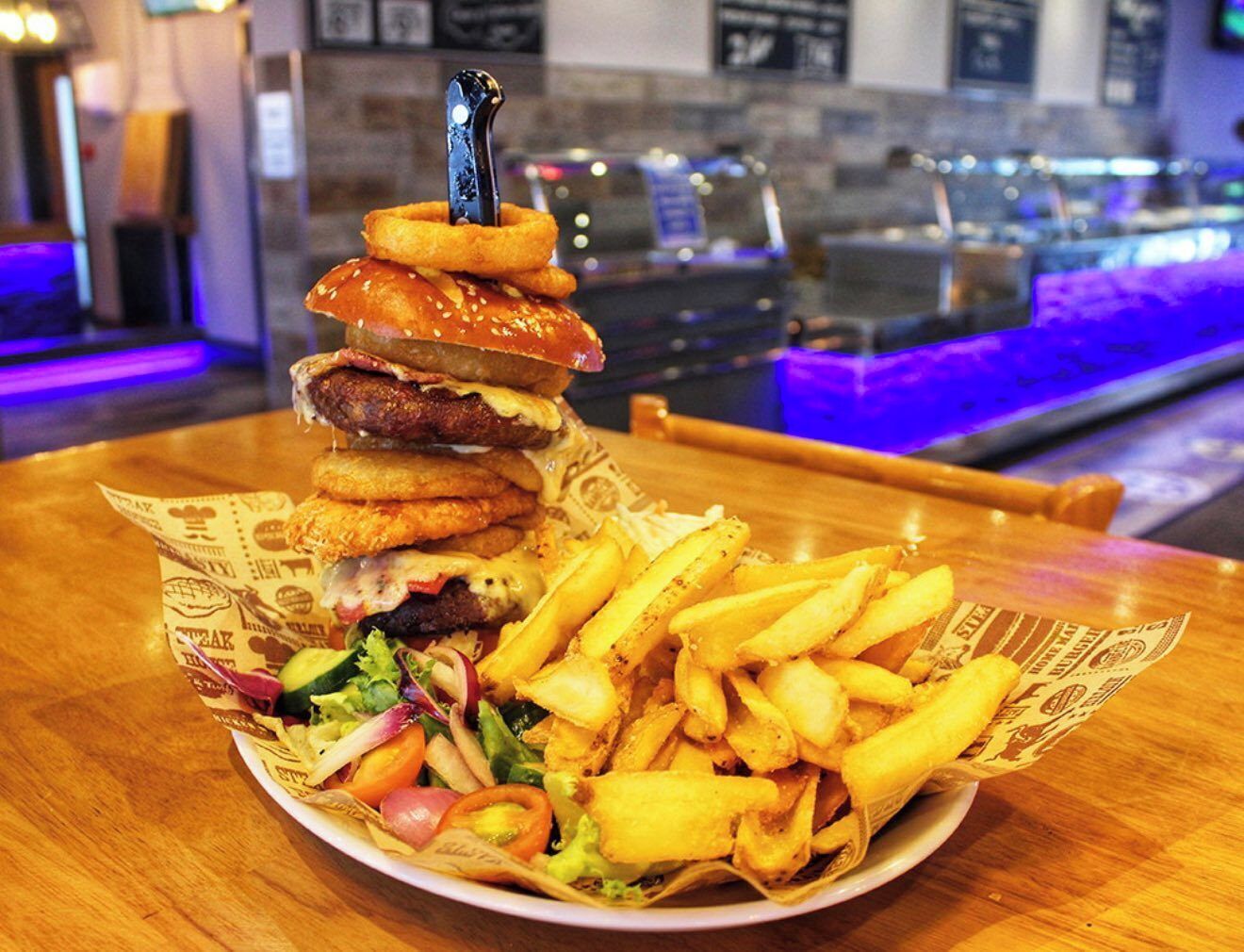 A plate of food with a burger, fries, and a salad.