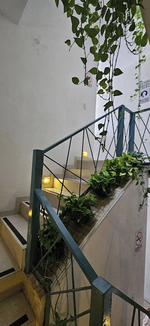 Eine Treppe mit Metallgeländern, Blumentöpfen und einem Rauchverbot-Schild.