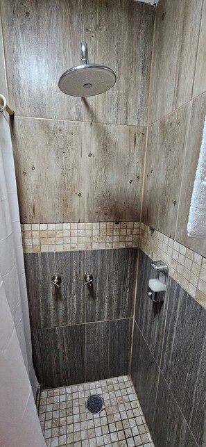 A shower with a handheld showerhead, a glass of water, and a soap dispenser. - Hotel Punto Oriente: 2 Beds, A/C, and Free Parking (Tonalá)