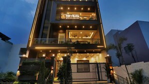 A multi-story building with a sign for 'The Oraya' hotel. - Palette The Oraya Greens (Lucknow)