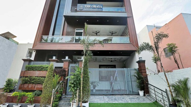 A multi-story building with balconies, a sign for 'The Oraya,' and a gated entrance. - Palette The Oraya Greens (Lucknow)