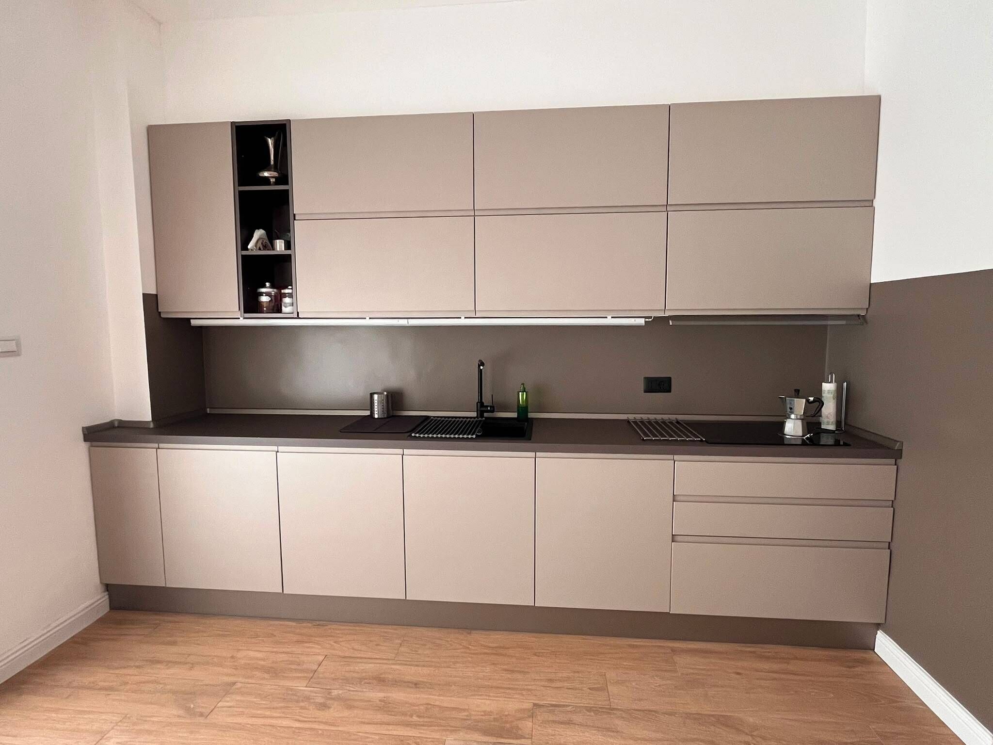 A modern kitchen with a built-in oven, a sink, and a countertop.