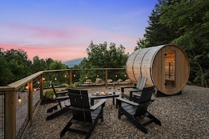 An outdoor seating area with a fire pit, wooden chairs, and a barrel structure. - New! Views, Sauna Spa Hottub Cantina, Dogs (Gatlinburg)
