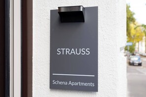 A sign for 'STRAUSS Schena Apartments' on a building wall. - Artisan Inspired · Strauss Boutique Studio (Vienna)
