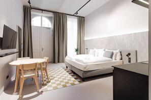 Ein modernes Schlafzimmer mit Bett, Nachttisch und einem an der Wand montierten Fernseher.