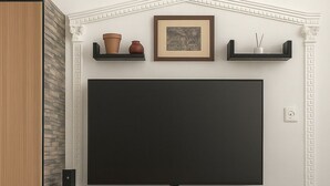 Un téléviseur à écran plat fixé au mur, agrémenté de moulures décoratives, une cheminée et un meuble intégré avec des tiroirs.