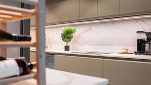 Una cucina moderna con piani di marmo, una macchina da caffè e una pianta in vaso.