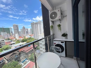 A balcony with a washing machine, a chair, and a potted plant. - ROMNEA MOON RESORT (Phnom Penh)