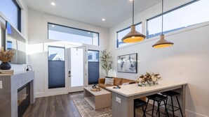 A modern kitchen with a central island, pendant lighting, and a view through large windows. - Boutique Spa Resort Adults-Only | Designed for Relaxation (Idaho Falls)