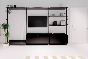 Ein modernes Wohnzimmer mit einer schwarzen Unterhaltungseinheit, einem Flachbildfernseher und einer Topfpflanze.