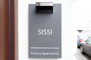 Une enseigne indiquant les appartements Schena, avec le nom « SISSI » bien visible.