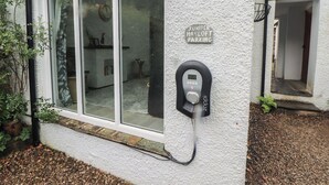 A building with a glass door, a parking sign, and a parking meter. - Juniper Hayloft (Ambleside)
