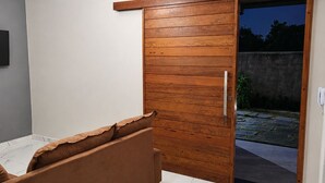 A bedroom with a bed, a wooden wardrobe, a sliding door, and a ceiling light fixture. - Porto Fino Residential Complex, 5 minutes from the city center. (Porto Seguro)