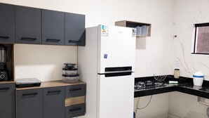 A kitchen with a refrigerator, cabinets, a countertop, and a window. - Porto Fino Residential Complex, 5 minutes from the city center. (Porto Seguro)