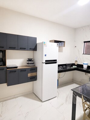 A kitchen with a refrigerator, cabinets, a countertop, and a window. - Porto Fino Residential Complex, 5 minutes from the city center. (Porto Seguro)