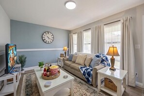 Ein Wohnzimmer mit Sofa, Couchtisch und einer Uhr an der Wand.