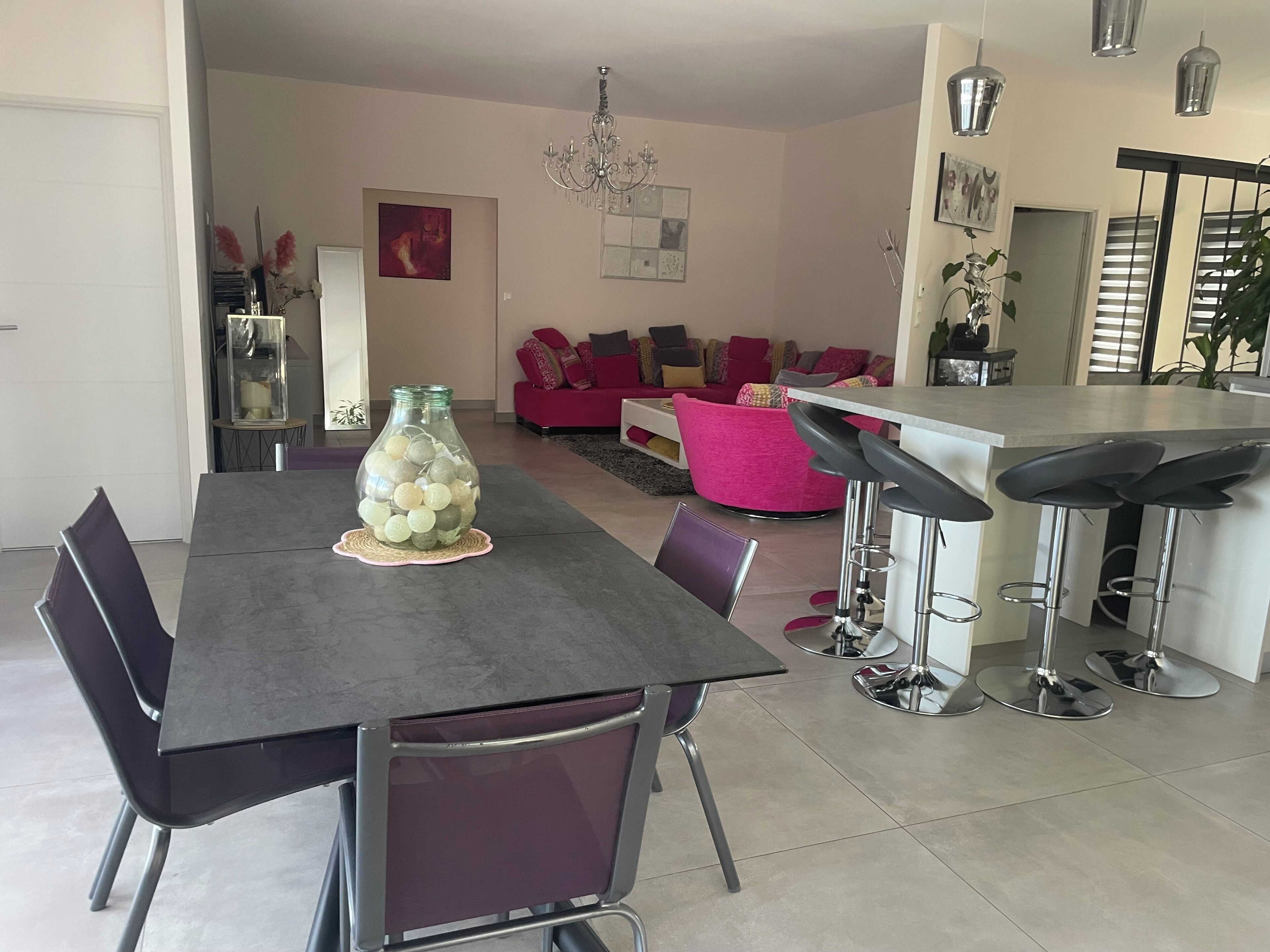 A modern dining area with a table, chairs, and a decorative glass jar.
