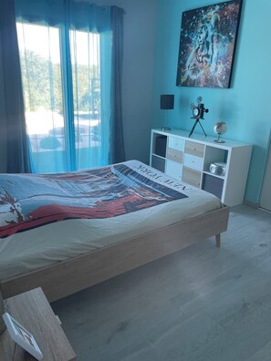 Ein Schlafzimmer mit einem Bett, einem Schminktisch, einem Globus, einer Uhr und einem Bild an der Wand.