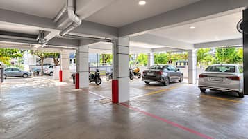 A parking garage with multiple levels, clear signage, and a fan for ventilation.