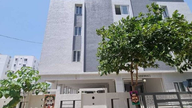 Un edificio de varias plantas con un estilo arquitectónico moderno, que destaca un elemento vertical y una entrada con portón.