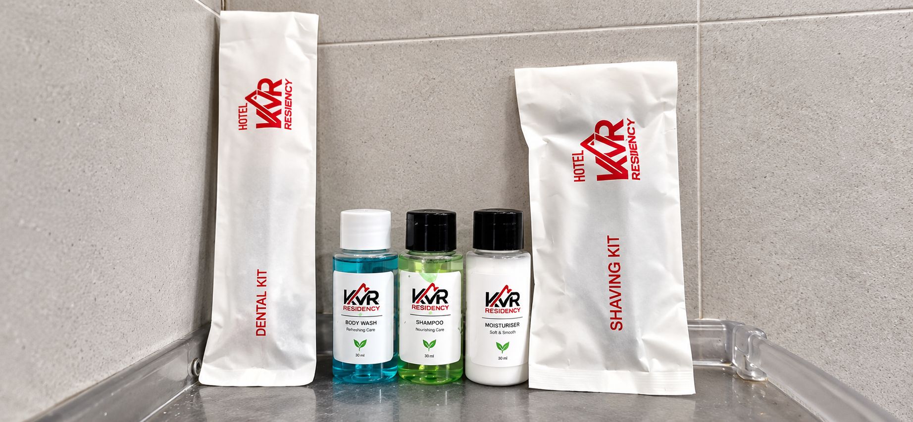 A bathroom with a dental kit and shaving kit, including body wash, shampoo, and moisturizer.