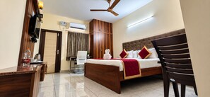 A hotel room with a bed, a desk, a chair, an air conditioning unit, and a ceiling fan. - Hotel Kvr Residency Tada  (Tada)